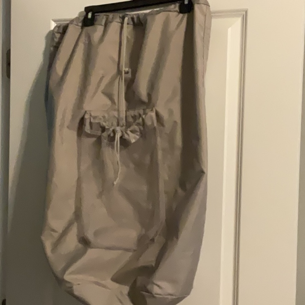 Large gray laundry bag with handle and backpack straps. Front and inside pockets